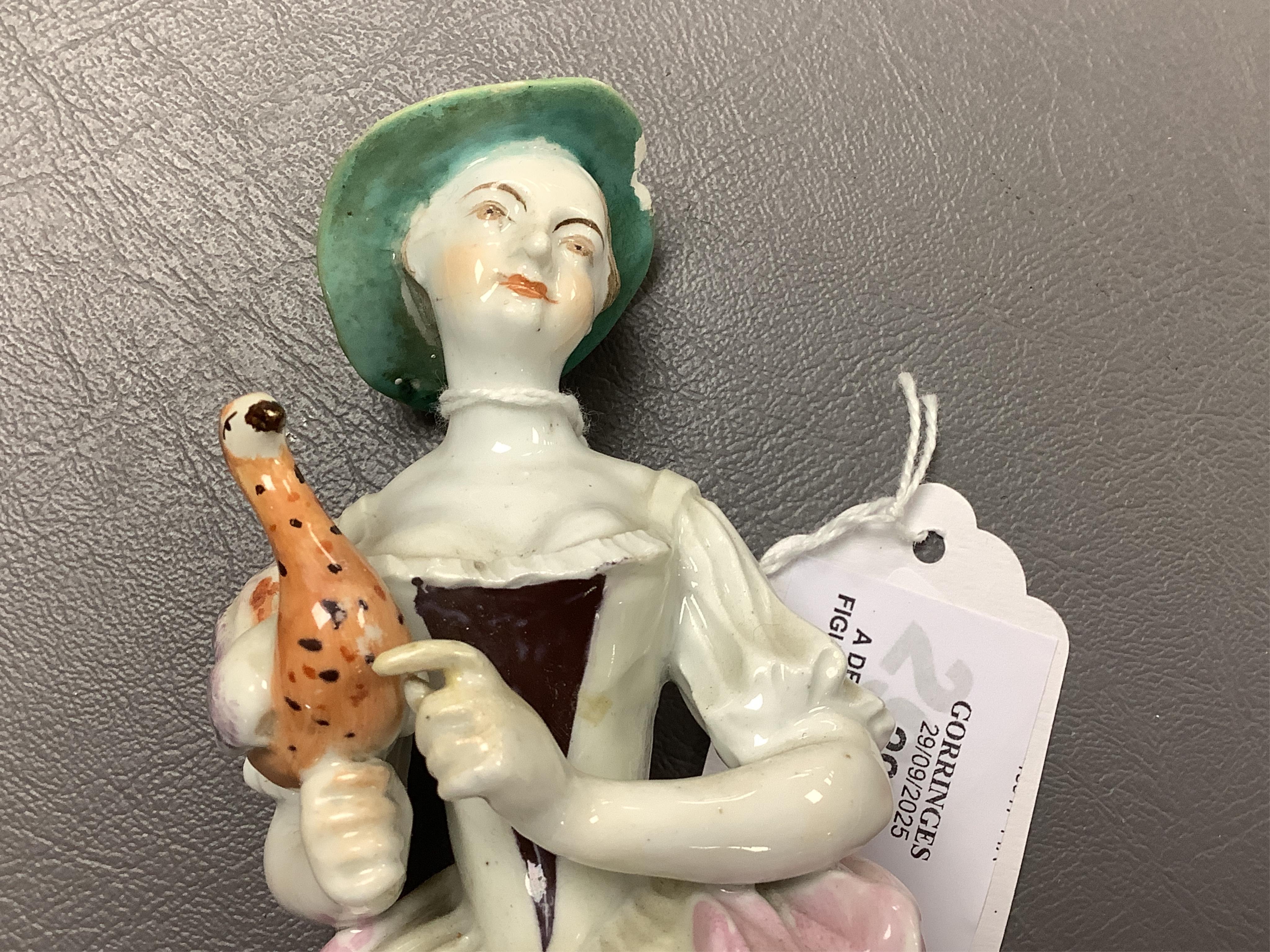 A Derby porcelain figure of a lady holding a bird, c.1760-65 and a Derby porcelain figure of a gentleman fruit seller, largest 24cm high (2)